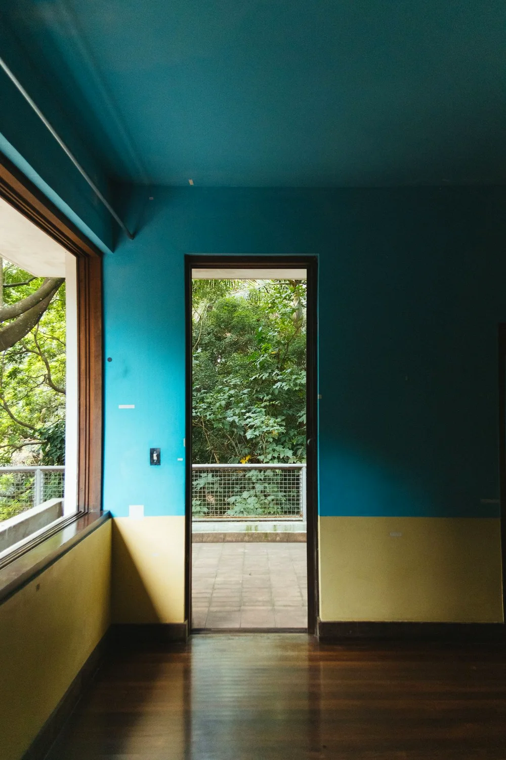 Ambiente com parede e teto pintados em azul petróleo e faixa amarela